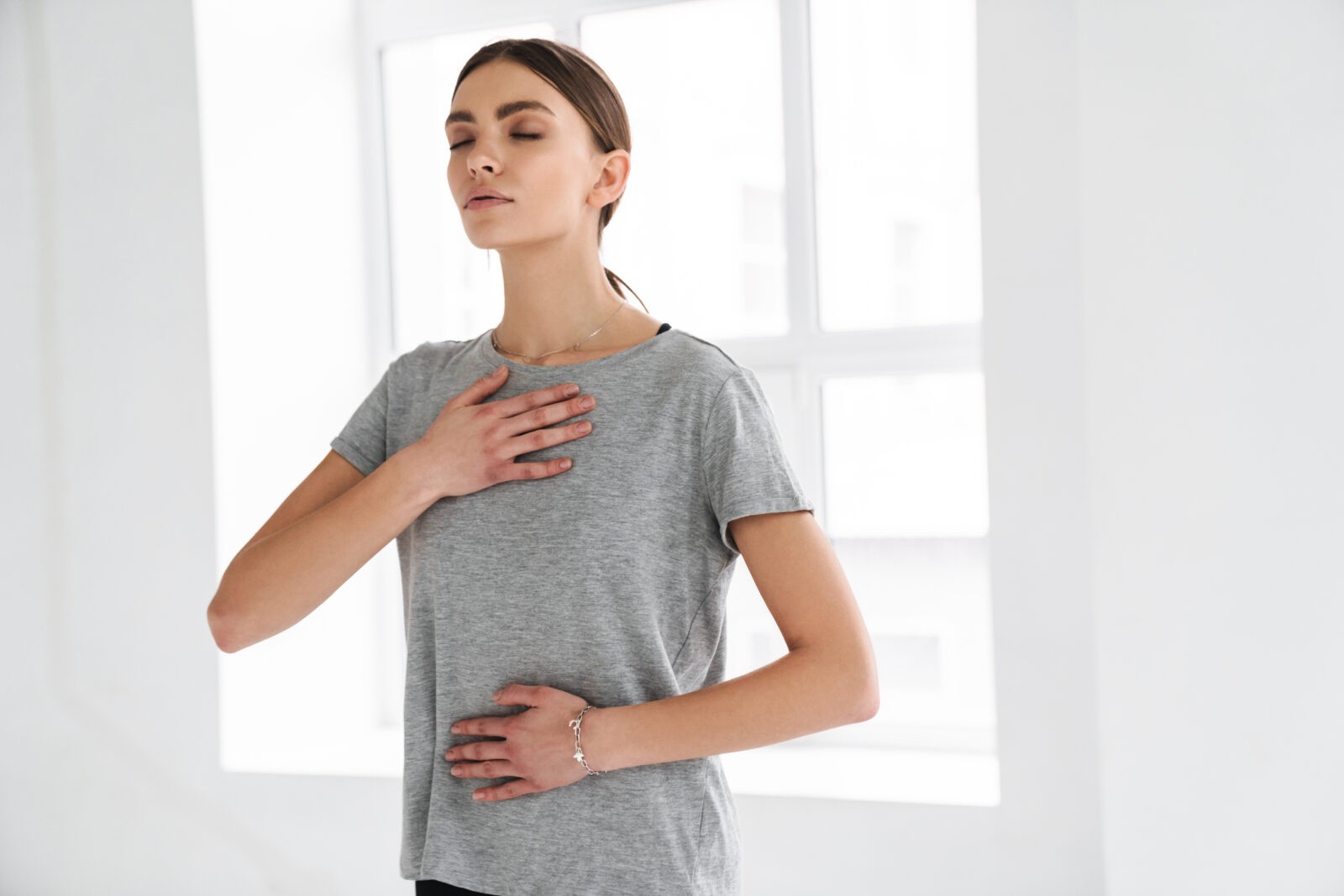 Athletic sportswoman doing breathing exercise during yoga practice